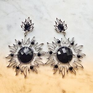Gothic or celestial-style dangle earrings featuring a sun motif